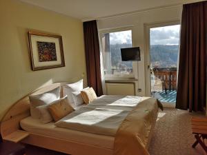 a bedroom with a large bed with a large window at Pension Talblick Bad Grund in Bad Grund