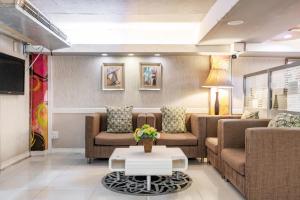 a living room with two couches and a tv at The Richy Place Guest House in Bangkok