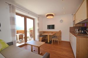 a kitchen and living room with a table and a dining room at Residence Apartment Talblick in San Leonardo in Passiria