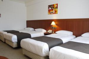 a hotel room with three beds in a room at Commodore Hotel Gyeongju in Gyeongju