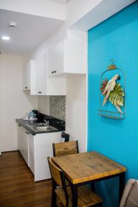 a kitchen with a table and a blue wall at Sitio Uno Residences in Roxas City