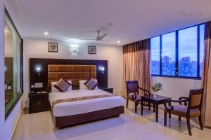 a hotel room with a bed and a table and chairs at Raj Residency in Hosdrug +42 photos