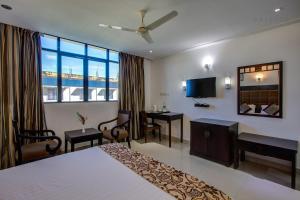a hotel room with a bed and a desk at Raj Residency in Hosdrug