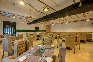 a restaurant with tables and chairs in a room at Raj Residency in Hosdrug