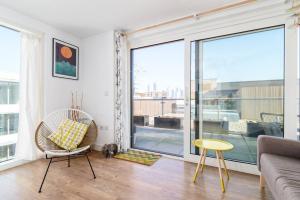 a living room with a couch and a large window at Lovely studio flat with terrace in Southeast London in London