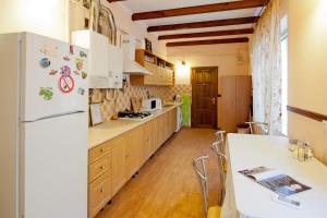 オデッサにあるUyutniyのキッチン(白い冷蔵庫、木製キャビネット付)