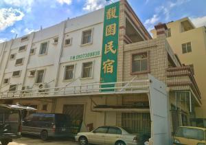 un edificio con una señal verde en el costado. en Fu Yuan B&B en Magong