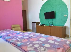 1 dormitorio con 1 cama y TV de pantalla plana en Fu Yuan B&B en Magong