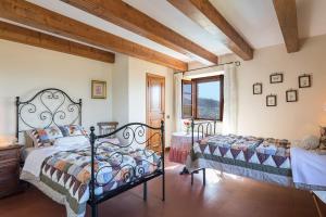 1 dormitorio con 2 camas y ventana en Villa La Cappella en Monticiano