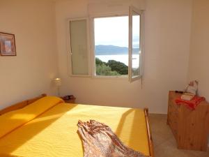 una camera con letto giallo e finestra di Residence Capicciolo a Olmeto Altre 74 foto