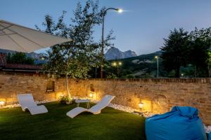 a backyard with two chairs and an umbrella and a table at RESIDENZA DON ALBERTO in Ornano Grande