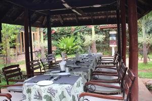 a patio area with tables, chairs and umbrellas at Afrika Lodges in Voi