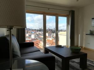uma sala de estar com uma cadeira, uma mesa e uma grande janela em Lisbon Grand View em Lisboa