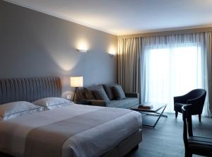a hotel room with a bed and a couch at Pelagos Suites Hotel & Spa in Kos