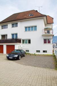 a black car parked in front of a white house at Hostel Villa Viva in Bregenz