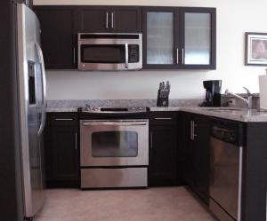 a kitchen with black cabinets and stainless steel appliances at Westover Arms Hotel in Miami Beach