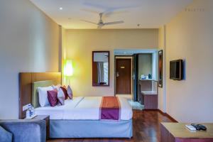 a hotel room with a bed and a couch at JK Residency Cheruvathur in Nīleshwar