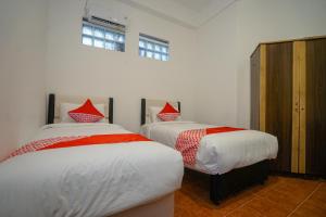 Tempat tidur dalam kamar di Super OYO 1844 Bravo Residence
