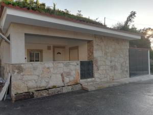 a house with a stone wall and a garage at Casa Morgado in Braga