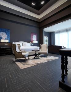 a bedroom with a bed and two chairs and a table at Pelagos Suites Hotel & Spa in Kos