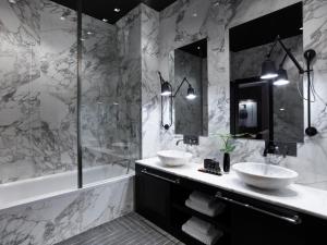 a black and white bathroom with two sinks and a tub at Pelagos Suites Hotel & Spa in Kos