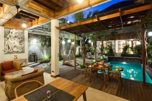 an outdoor patio with a pool and a table and chairs at Bije Boutique & Gallery in Ubud