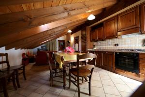 una cocina con mesa de madera y sillas. en Valley Vacanze en Brusson