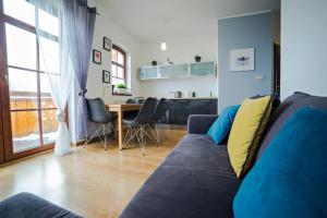 - un salon avec un canapé bleu et une table dans l'établissement Apartment Sun & Snow Centrum Obrońców Pokoju, à Karpacz