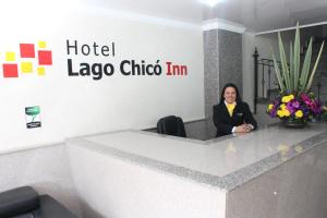Hoteles Bogotá Inn Lago Chico في بوغوتا: امرأة تجلس في مكتب في شركة laoco choco