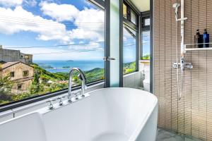 a bathroom with a sink and a large window at H& Jiufen Ore Inn in Jiufen