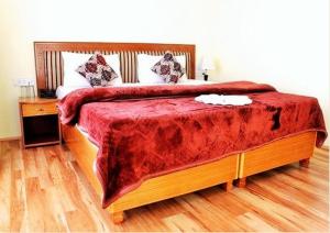 a bedroom with a large bed with a red blanket at Himalayan Residency Ladakh in Leh