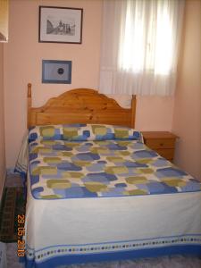 セゴビアにあるHostal Vadamaのベッドルーム1室(青と黄色の掛け布団付きのベッド1台付)