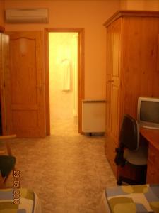 Habitación con pasillo con puerta y TV en Hostal Vadama, en Segovia