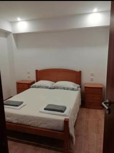 a bedroom with a bed with white sheets and two night stands at Casa Morgado in Braga