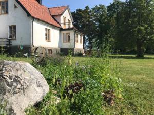 ein weißes Haus mit einem Felsen im Hof in der Unterkunft Silte Siglajvs 147 in Havdhem