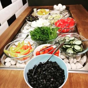 a table topped with bowls of different types of food at Hotel Bulevard in Hanko