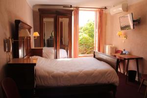 een slaapkamer met een bed en een raam bij Hôtel Le Commerce in Mirepoix