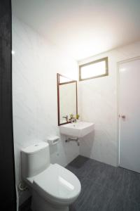 a white bathroom with a toilet and a sink at NK Residence Sakon Nakhon in Sakon Nakhon