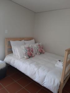 ジョージにあるRustverseker Self Catering Accommodationのベッド(白いシーツ、枕付)