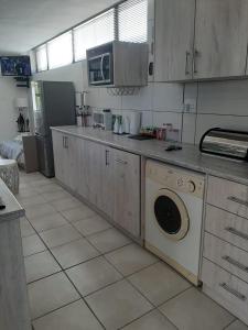 a kitchen with a washing machine and a microwave at Bergsight Self Catering Accommodation in George