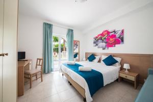 a bedroom with a bed and a desk and a window at Hotel Parco Delle Agavi in Ischia