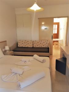 ein Zimmer mit 2 Betten und einem Sofa darin in der Unterkunft Sophie Studios in Roda