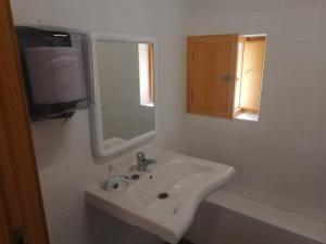 a white bathroom with a sink and a mirror at Casón Salto de Roldán in Sabayés