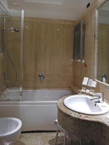 a bathroom with a tub, toilet and sink at Pinewood Hotel Rome in Rome