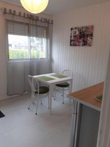 eine Küche mit einem Tisch und Stühlen sowie einem Fenster in der Unterkunft La belle étoile in Varennes-en-Argonne