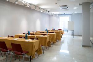 uma grande sala com mesas e cadeiras e um quadro branco em Hotel Sercotel Tres Luces em Vigo