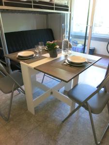 einen Tisch mit Tellern und Gläsern und eine Pflanze darauf in der Unterkunft Joli studio A front de mer in Saint-Raphaël