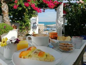 una mesa cubierta con un plato de comida y bebida en La Bella Trani - Suites and B&B, en Trani