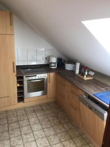 a kitchen with wooden cabinets and a stove at Ferienwohnung Kuschelmuschel Flensburg - Handewitt in Handewitt