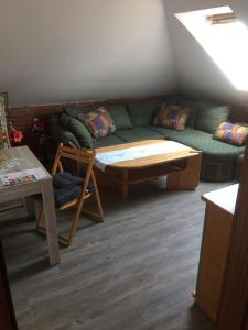 ein Wohnzimmer mit einem Sofa und einem Tisch in der Unterkunft Ferienwohnung Kuschelmuschel Flensburg - Handewitt in Handewitt